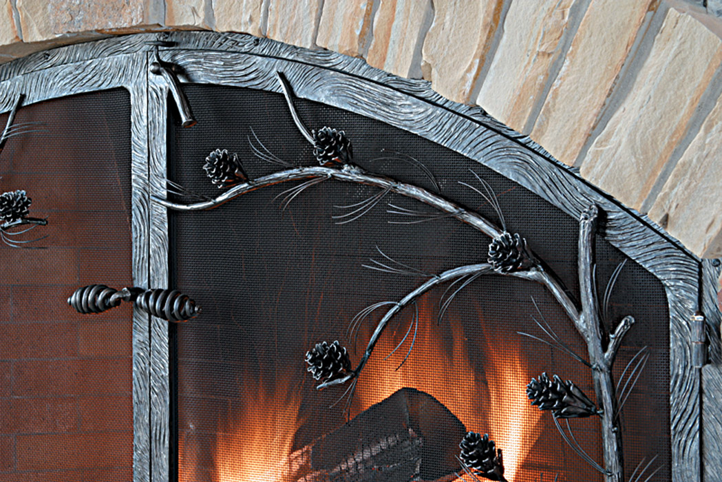fireplace screen with branches, pine needles and pine cones of forged metal
